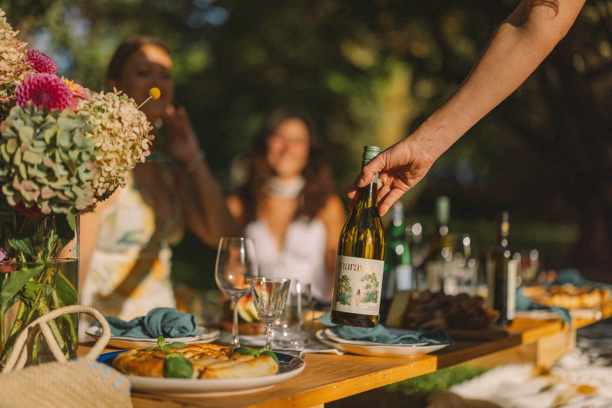 friends sharing chilled bottle of Marlborough Sauvignon Blanc at dinner