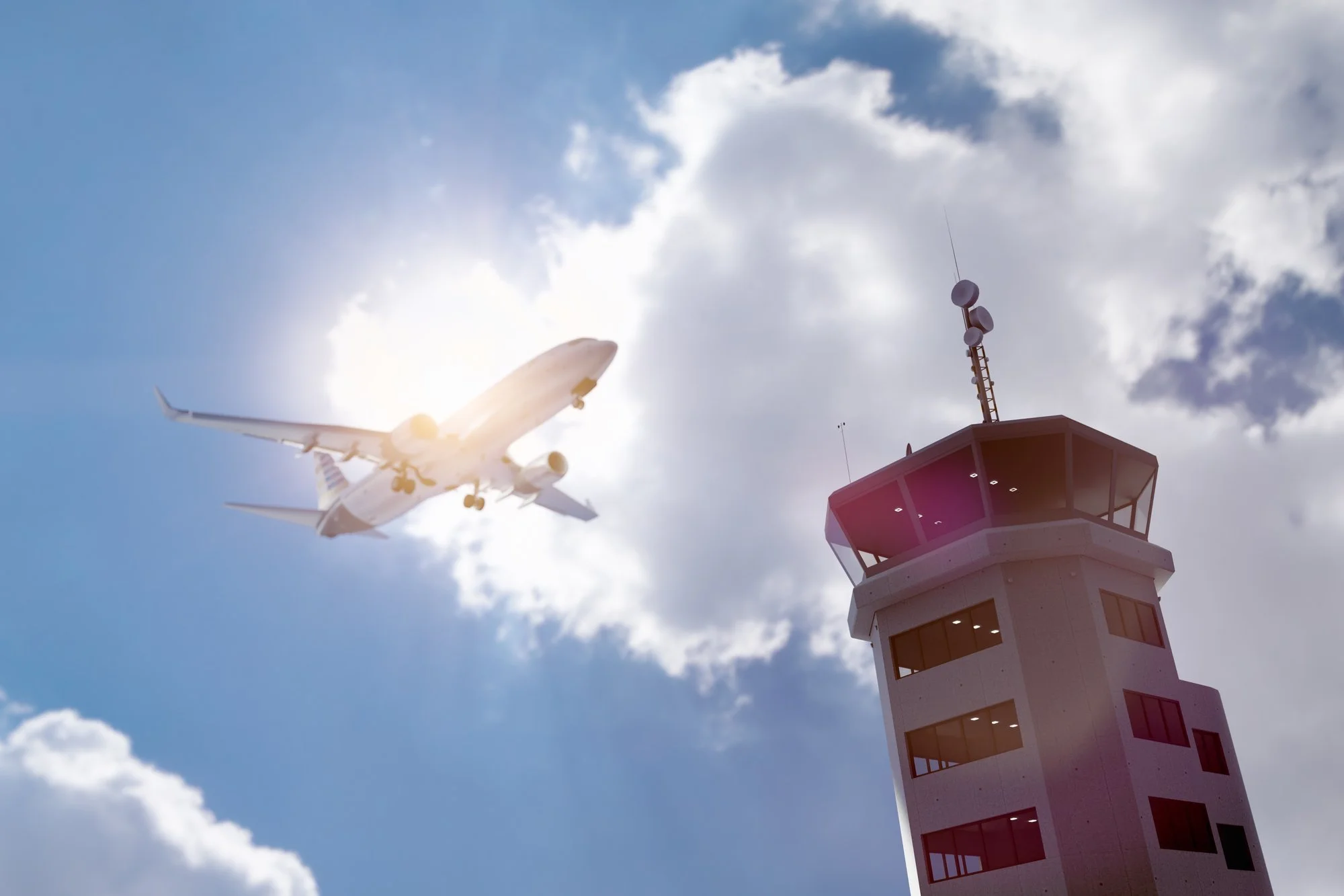 Airplane flying past an air traffic control tower for aspiring FAA air traffic controllers