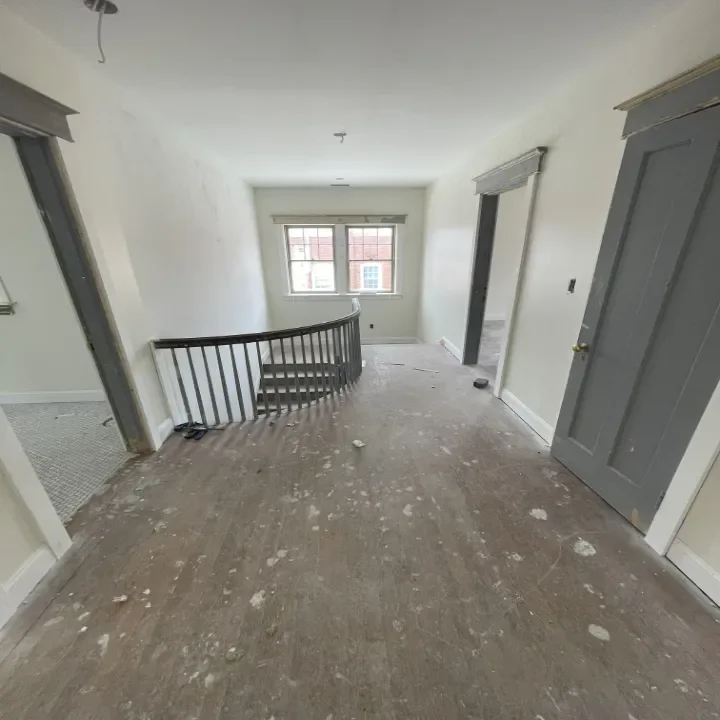 Empty room in a house under renovation with a curved stair railing.