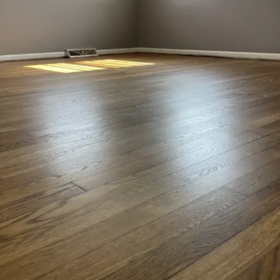 Empty room with hardwood floors, gray walls.