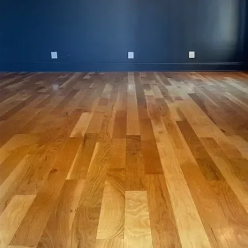Empty room with a hardwood floor and dark blue wall.
