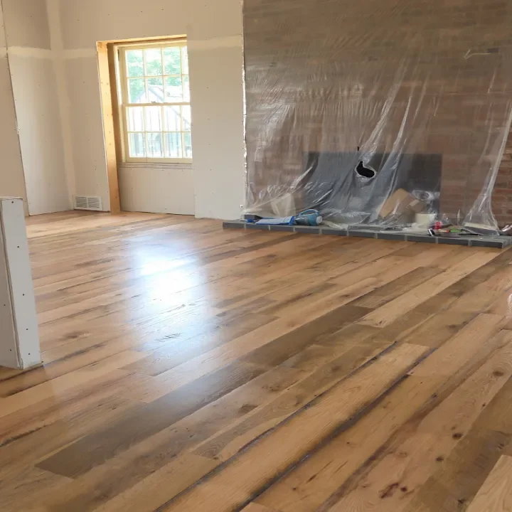 Interior of a house under renovation, showing new wood flooring.