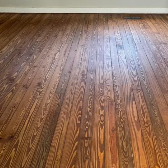 Wooden floor with a white baseboard.
