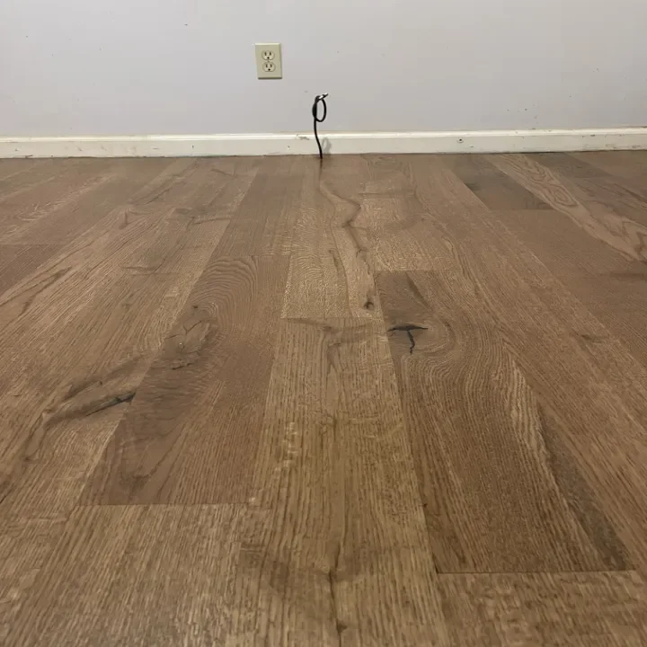 Close-up of wooden floor and a plain wall.