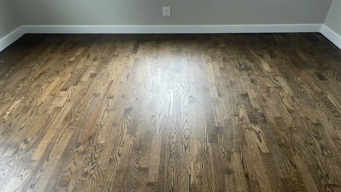 Empty room with hardwood flooring after installation.
