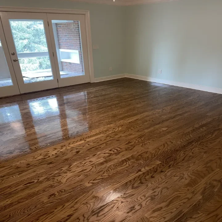 Empty room with hardwood floors and light blue walls.