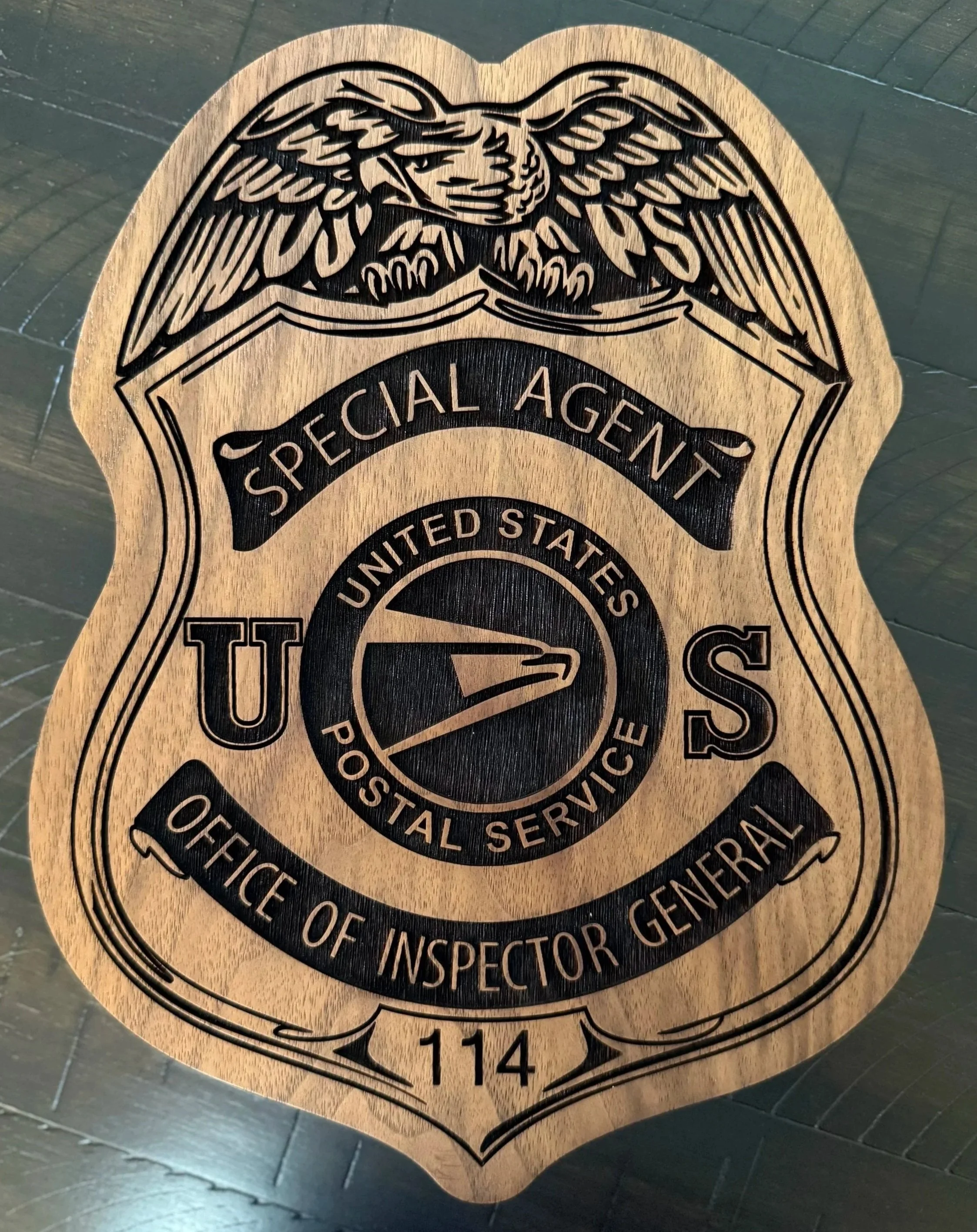 Wooden badge with a black engraved United States Bureau of Alcohol, Tobacco, Firearms and Explosives (ATF) emblem and the text 'Special Agent' and 'Office of Inspector'.