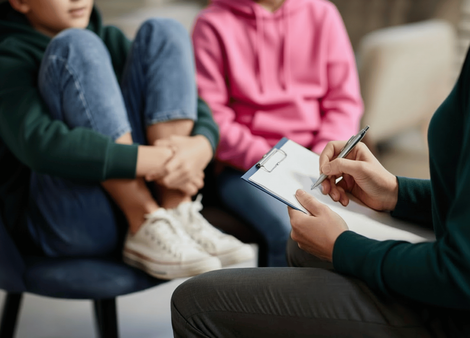 Therapist taking notes during a child therapy session at Throughline Psychotherapy in Raleigh, NC