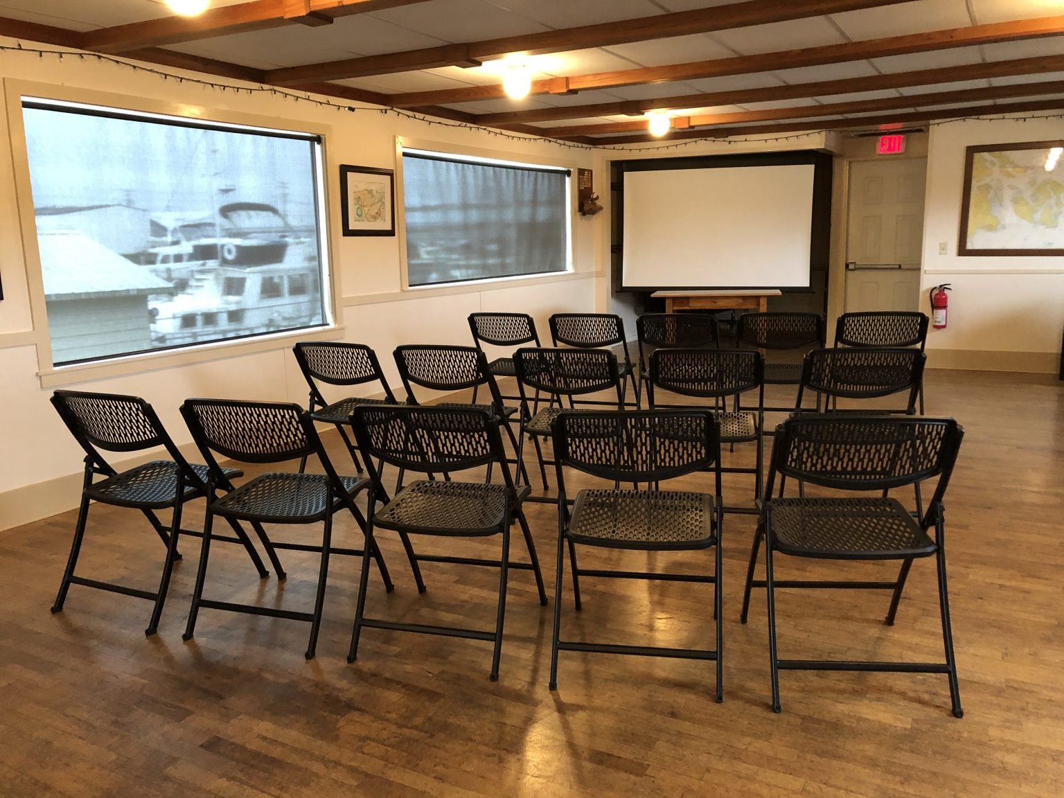 Chairs are arranged in front of a projection screen for a presentation.