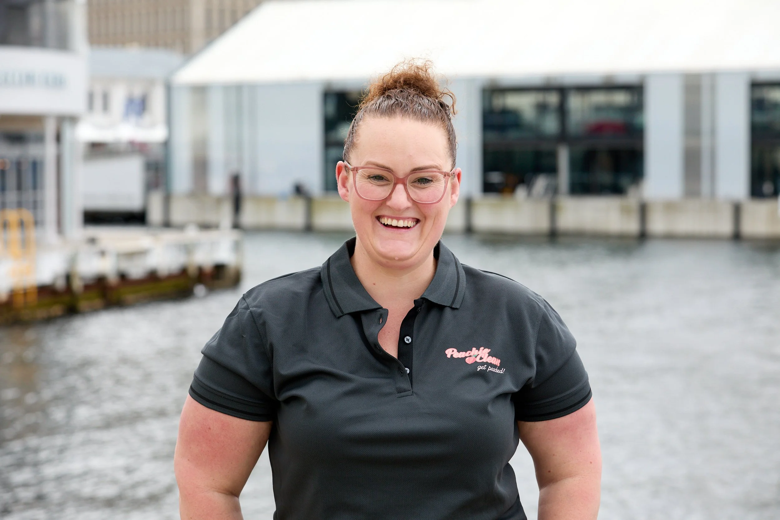 Peachie Clean Founder smiling in uniform at Hobart waterfront, Tasmania