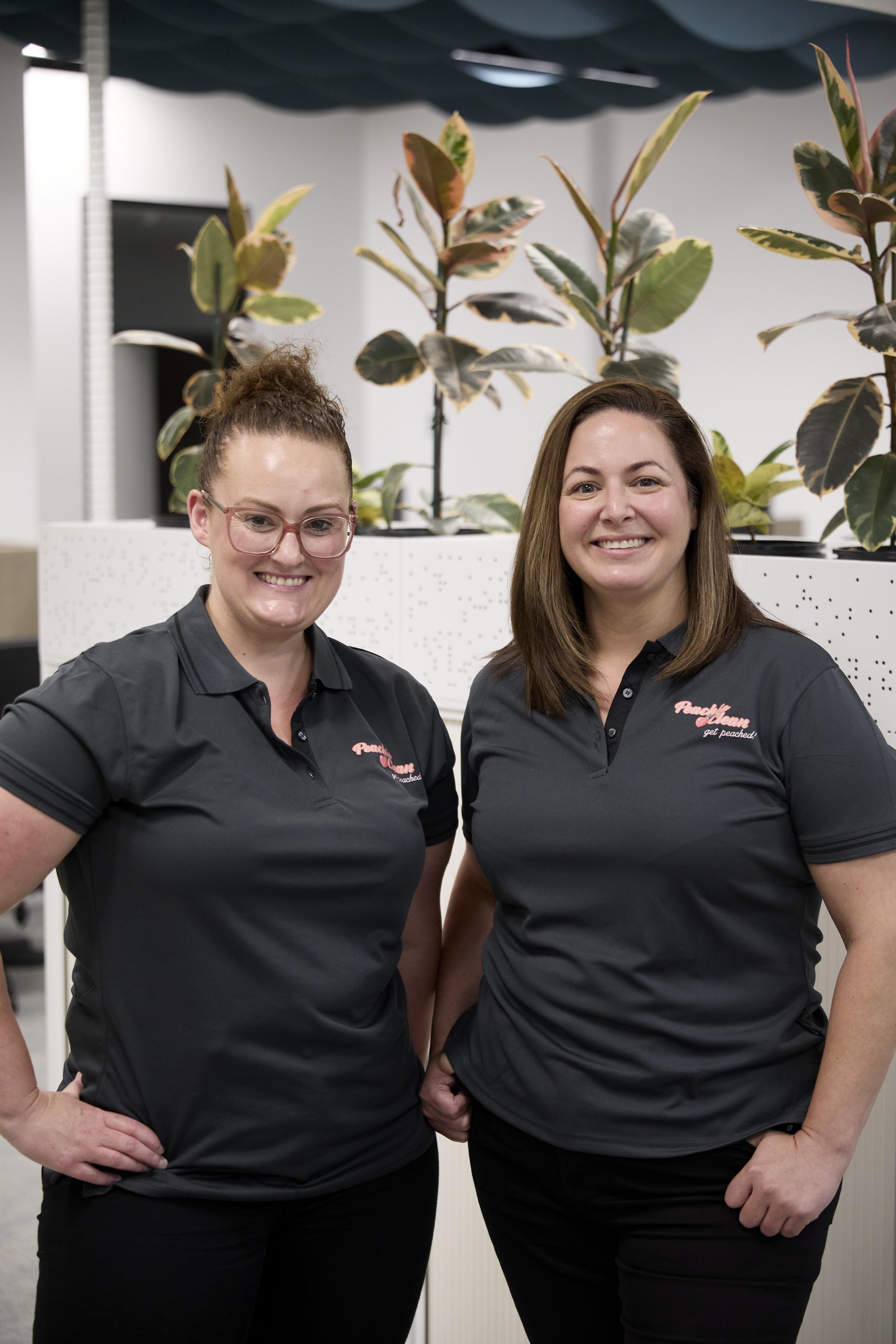Peachie Clean team members standing together in modern Hobart office, professional cleaning staff portrait