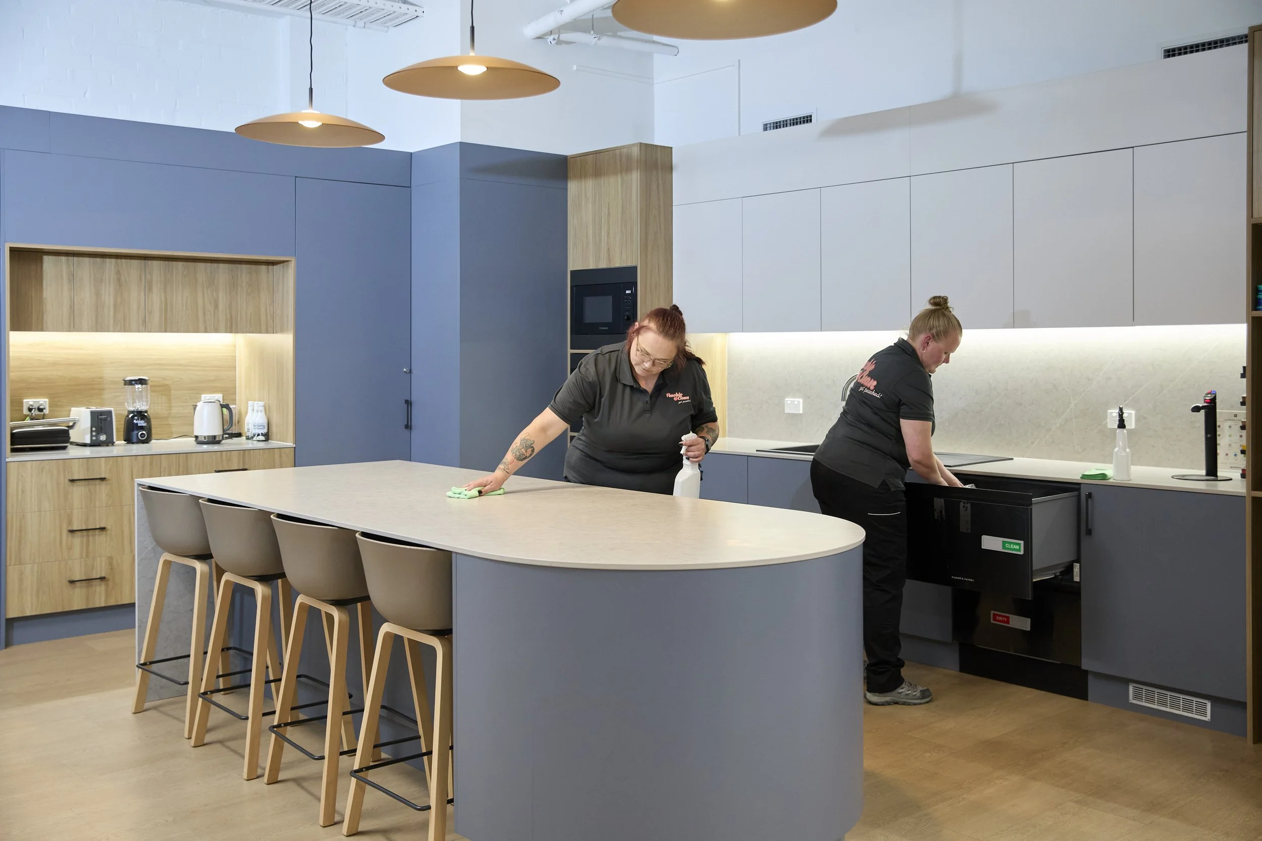 Peachie Clean team cleaning office kitchen in Hobart, wiping surfaces and maintaining hygiene in a modern workplace break area