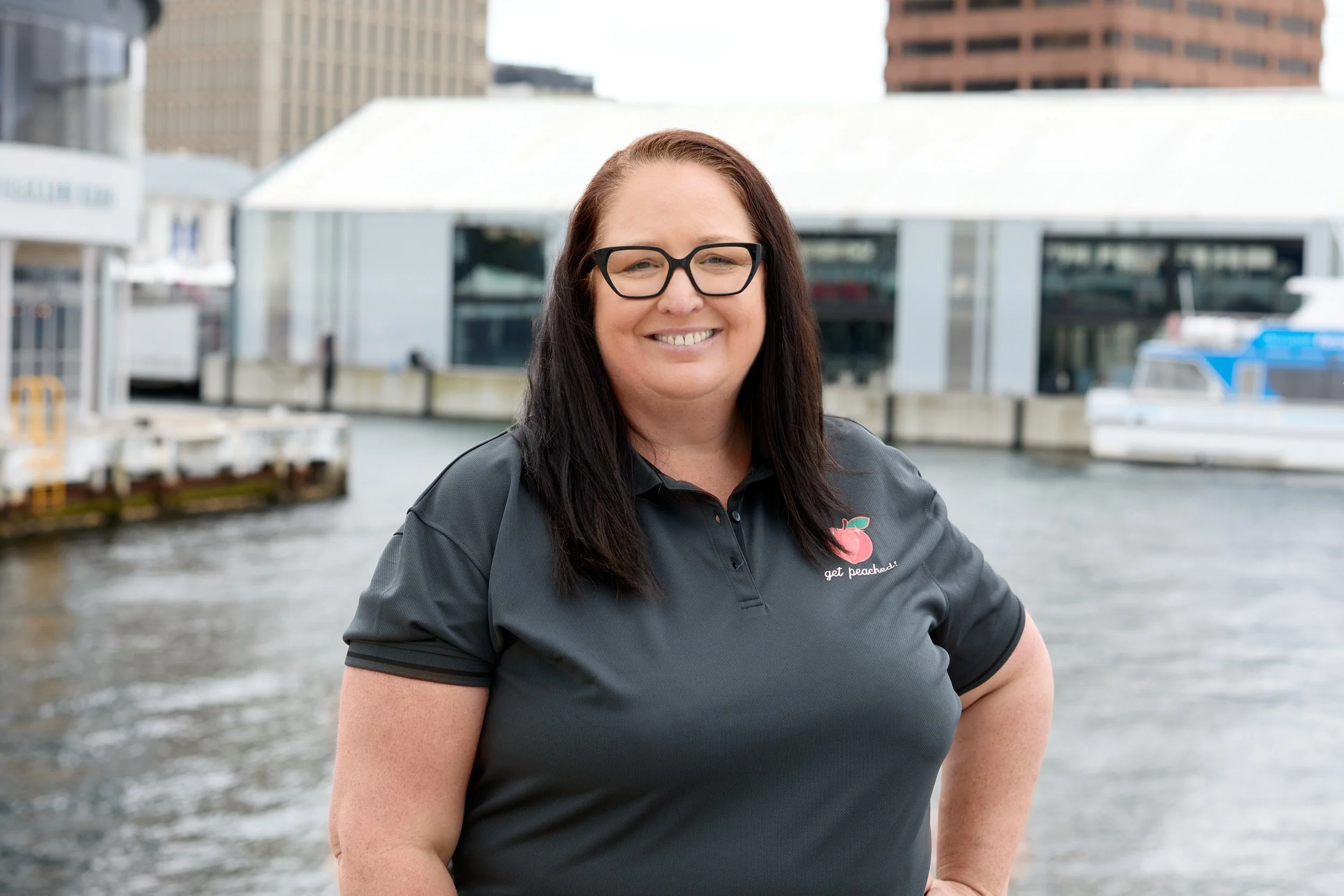 Peachie Clean Admin smiling in uniform at Hobart waterfront, Tasmania