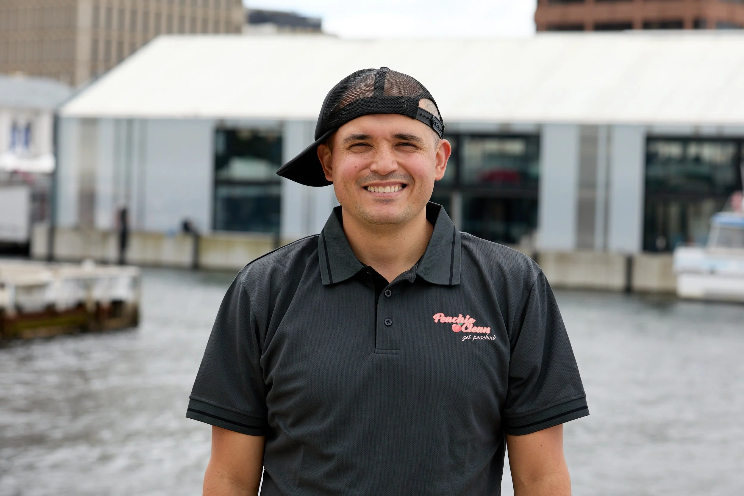 Peachie Clean supervisor smiling in uniform at Hobart waterfront, Tasmania