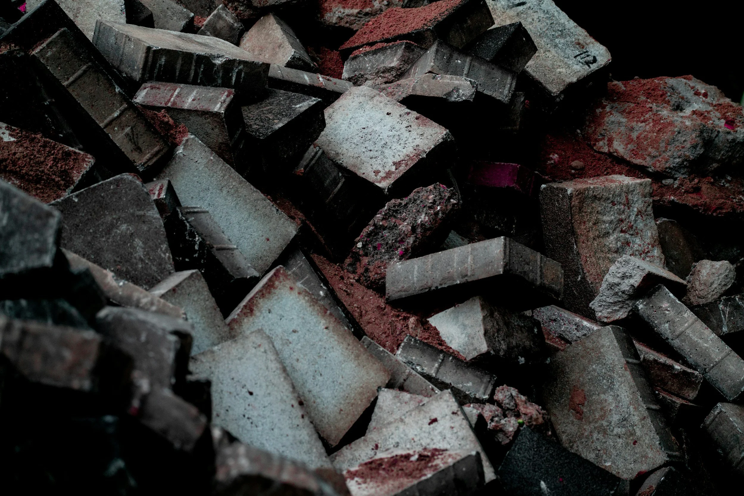 Close-up of scattered bricks and rubble in dark lighting.