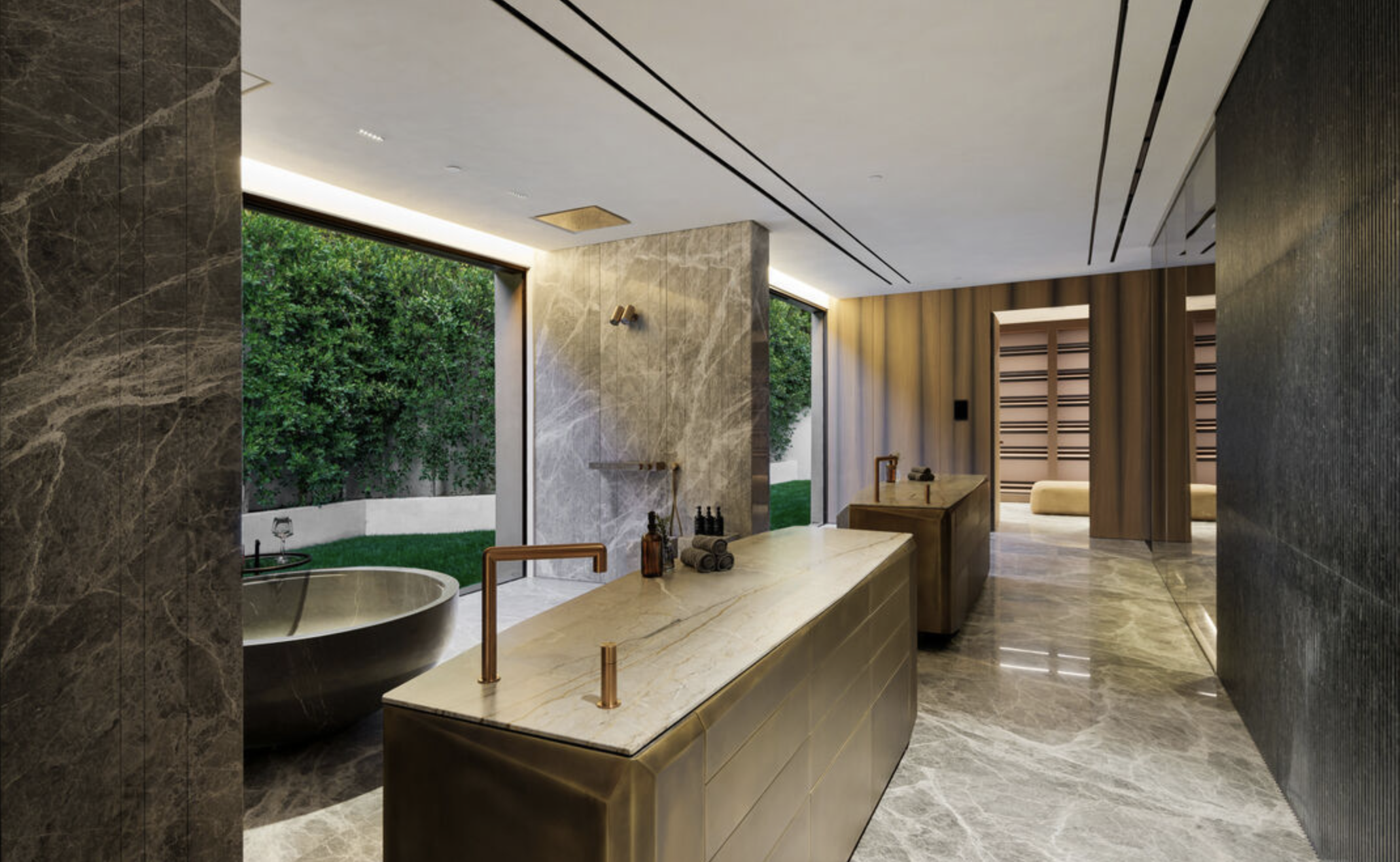 Modern bathroom with marble and dark stone surfaces, large windows overlooking a green yard, and minimalist fixtures.