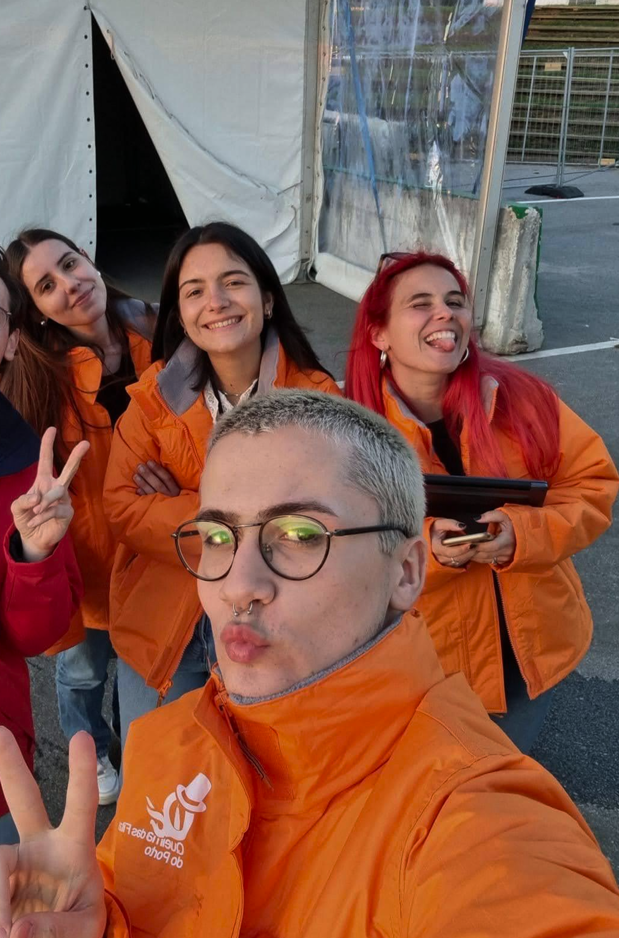 Grupo de pessoas sorrindo ao tirar selfie, todas utilizam Casacos Laranja devido à sua intervenção na Prevenção de Comportamentos de Risco durante a Queima das Fitas.