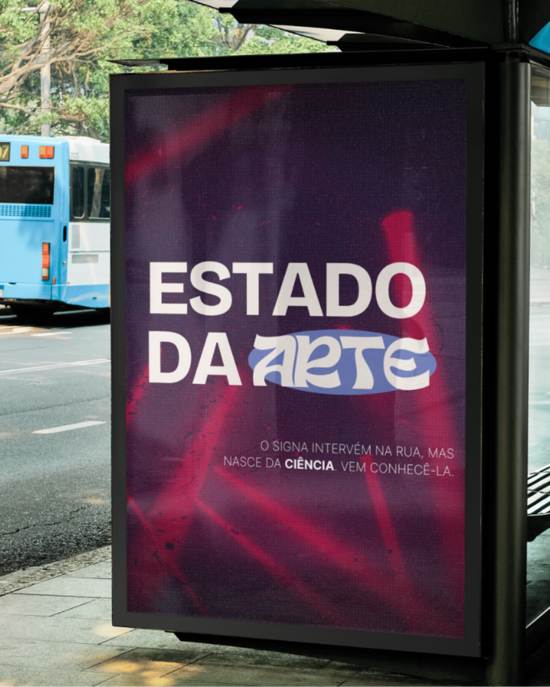 Cartaz na rua com a frase "Estado da Arte" e uma mensagem menor abaixo. O fundo é roxo com detalhes em vermelho e branco. Há um autocarro azul no fundo na rua.