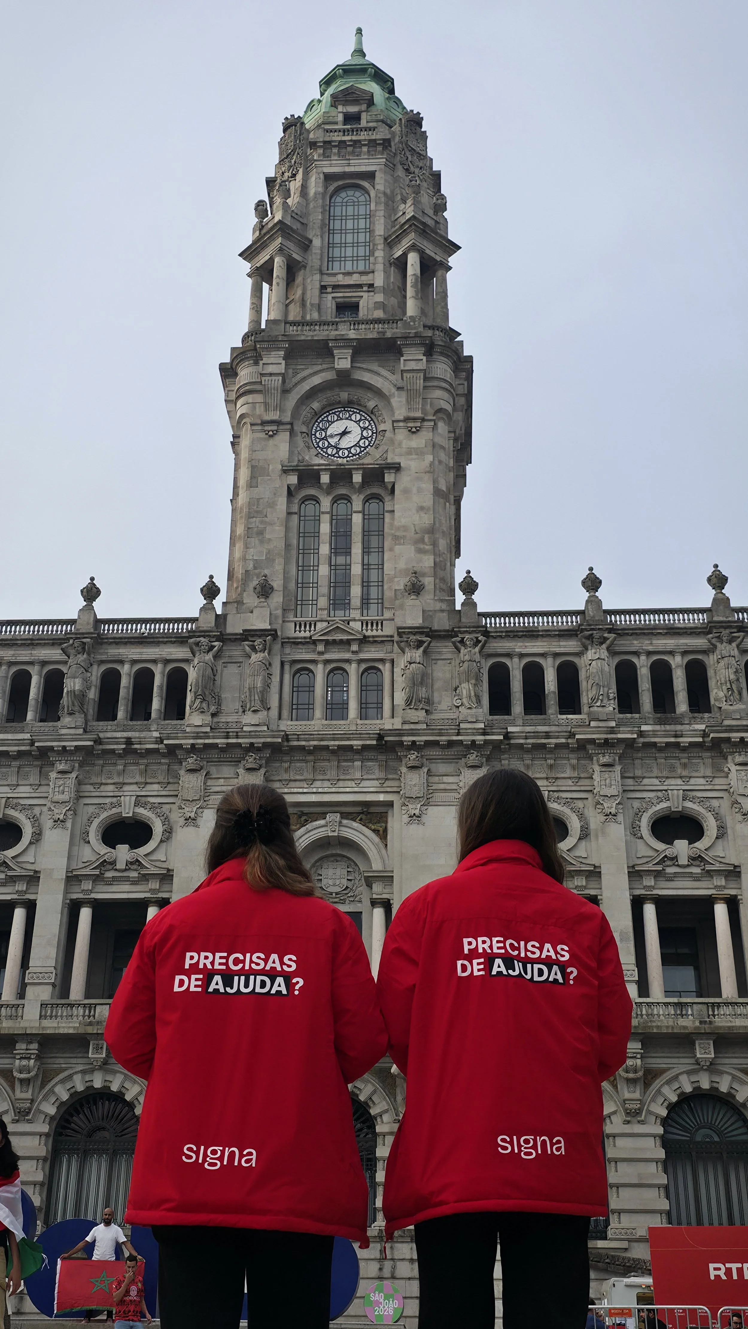 Signa team wearing their red jackets with a "Need help?" message on the back.