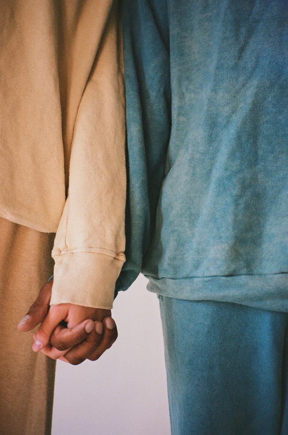 A close-up of two people holding hands.
