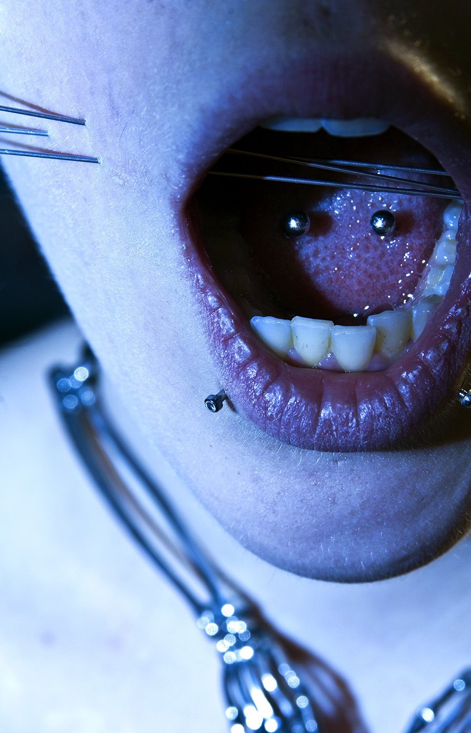 Cheek skewer play piercing photoshoot for Pain Magazine.