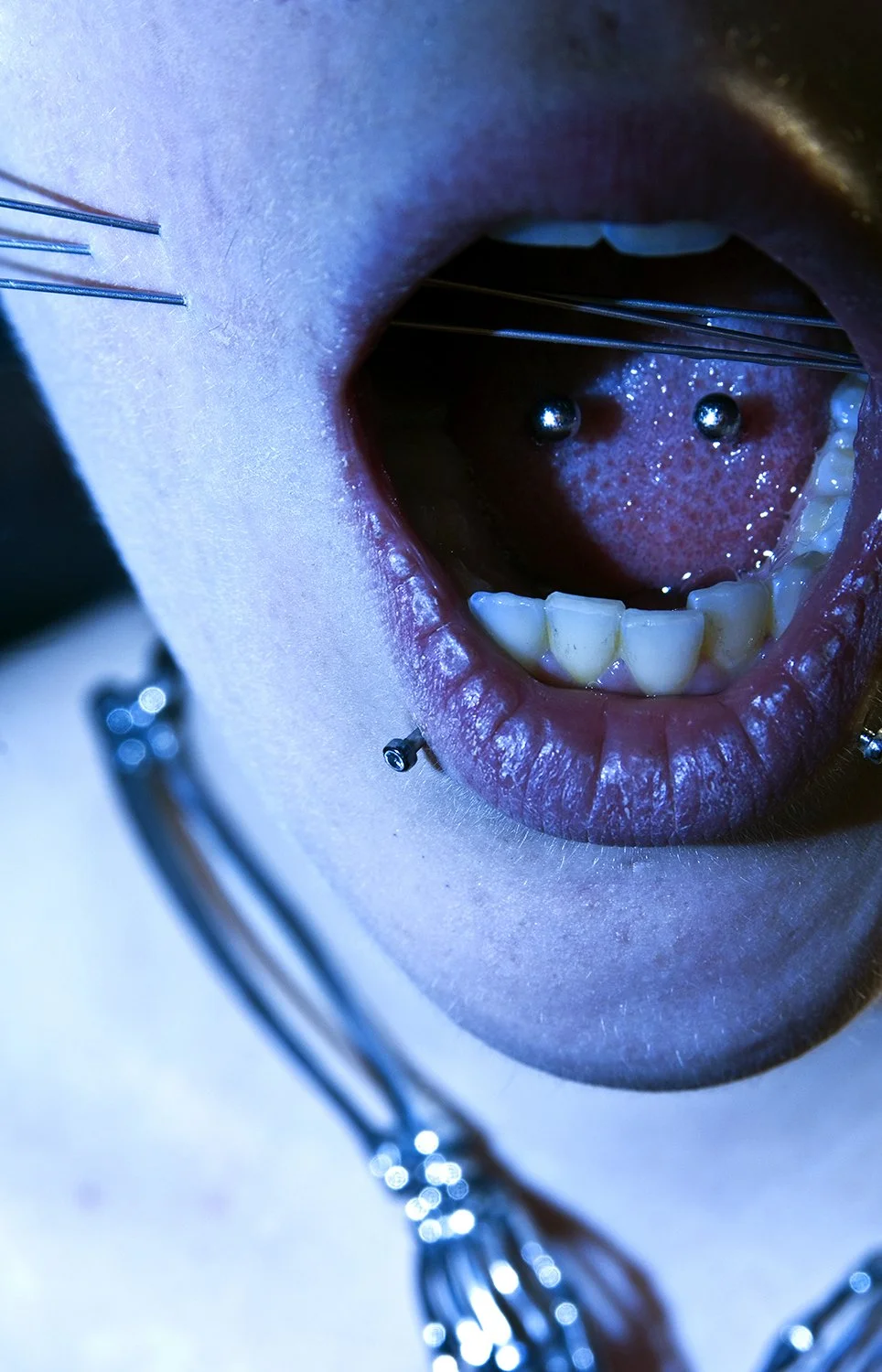 Cheek skewer play piercing photoshoot for Pain Magazine.