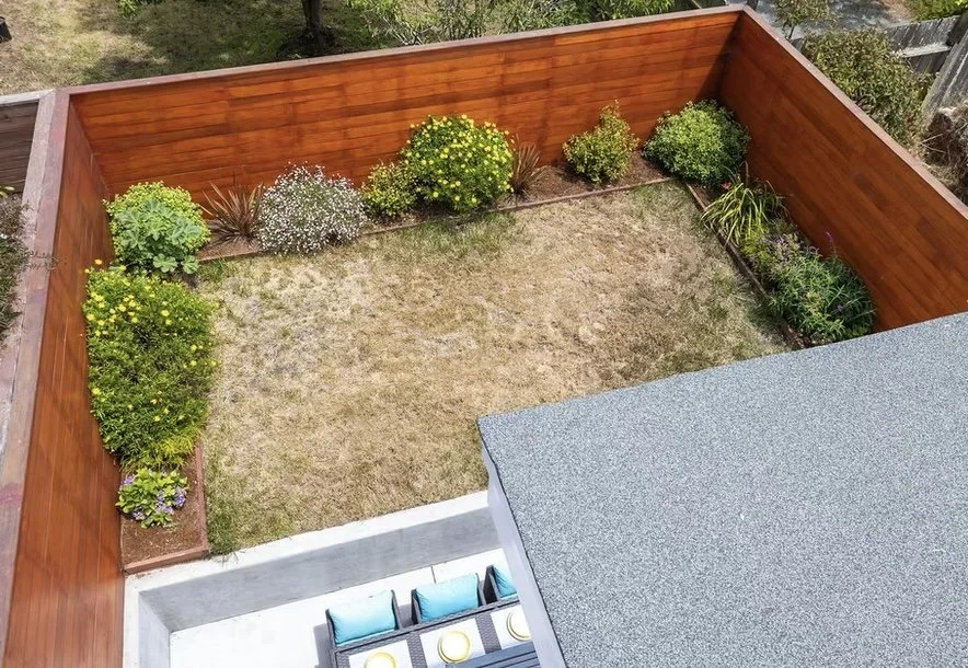 We optimized the perimeter beds with a smart drip irrigation system and ornamental plantings to maximize beauty in a compact space. This photo was taken months later. 