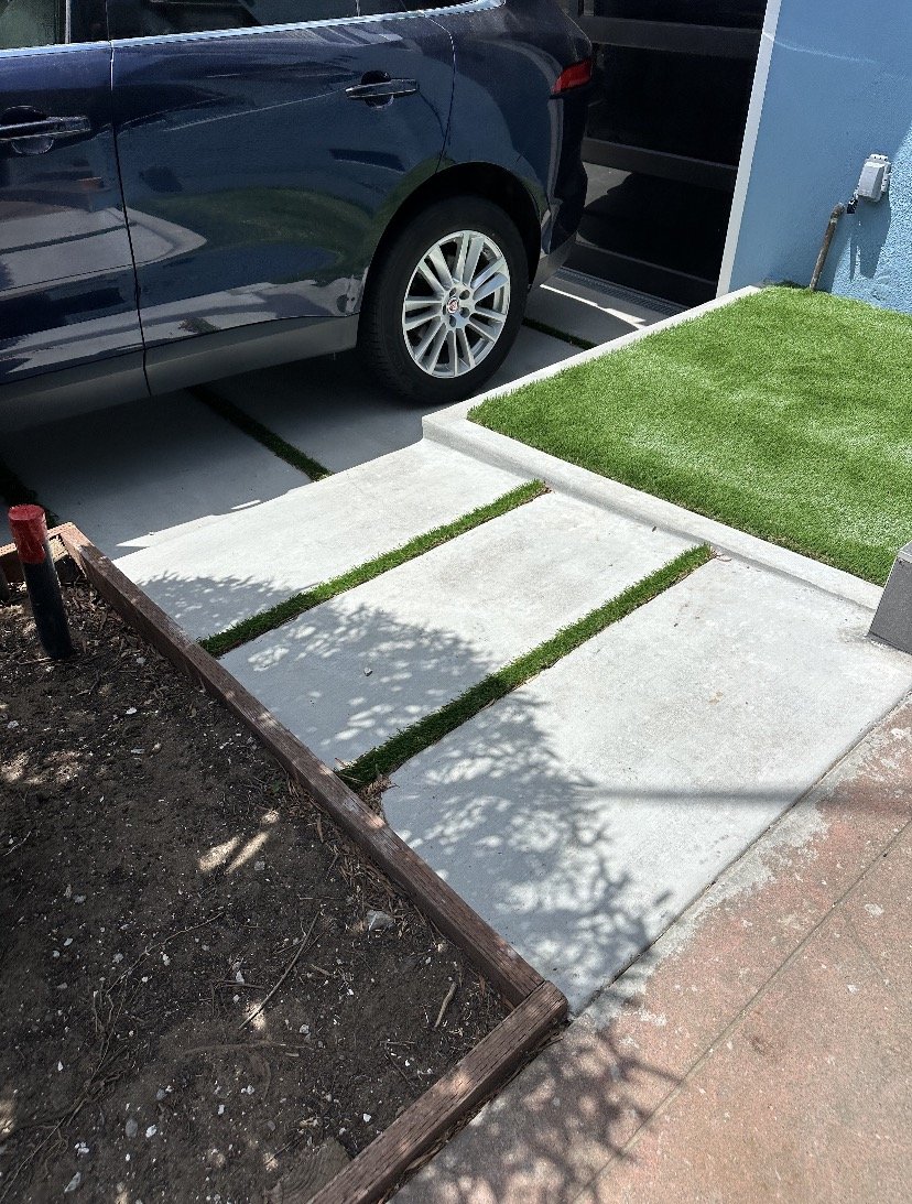Sod installation and sub-grade preparation. Work includes precise excavation and grading to create seamless 'ribbon' turf accents between concrete pavers, ensuring proper drainage and a level finish.