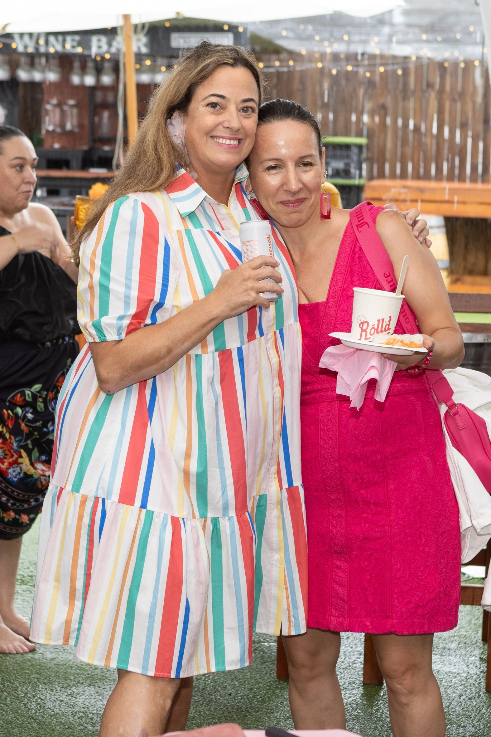 Two friends embracing and smiling at a Sydney BraLess Brunch event