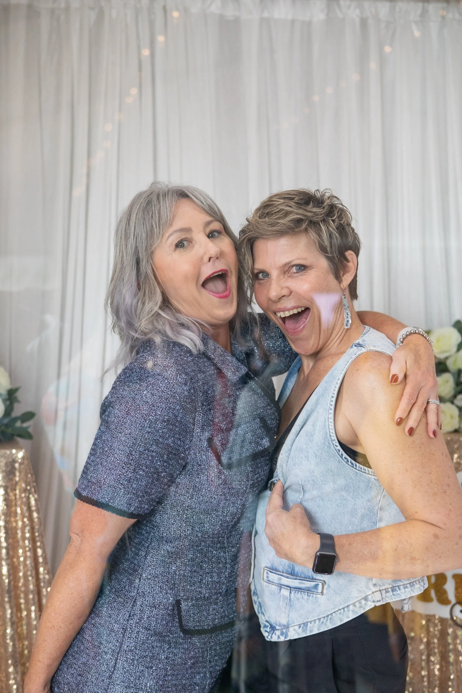 Two friends being cheeky in the photobooth at BraLess Brunch Brisbane