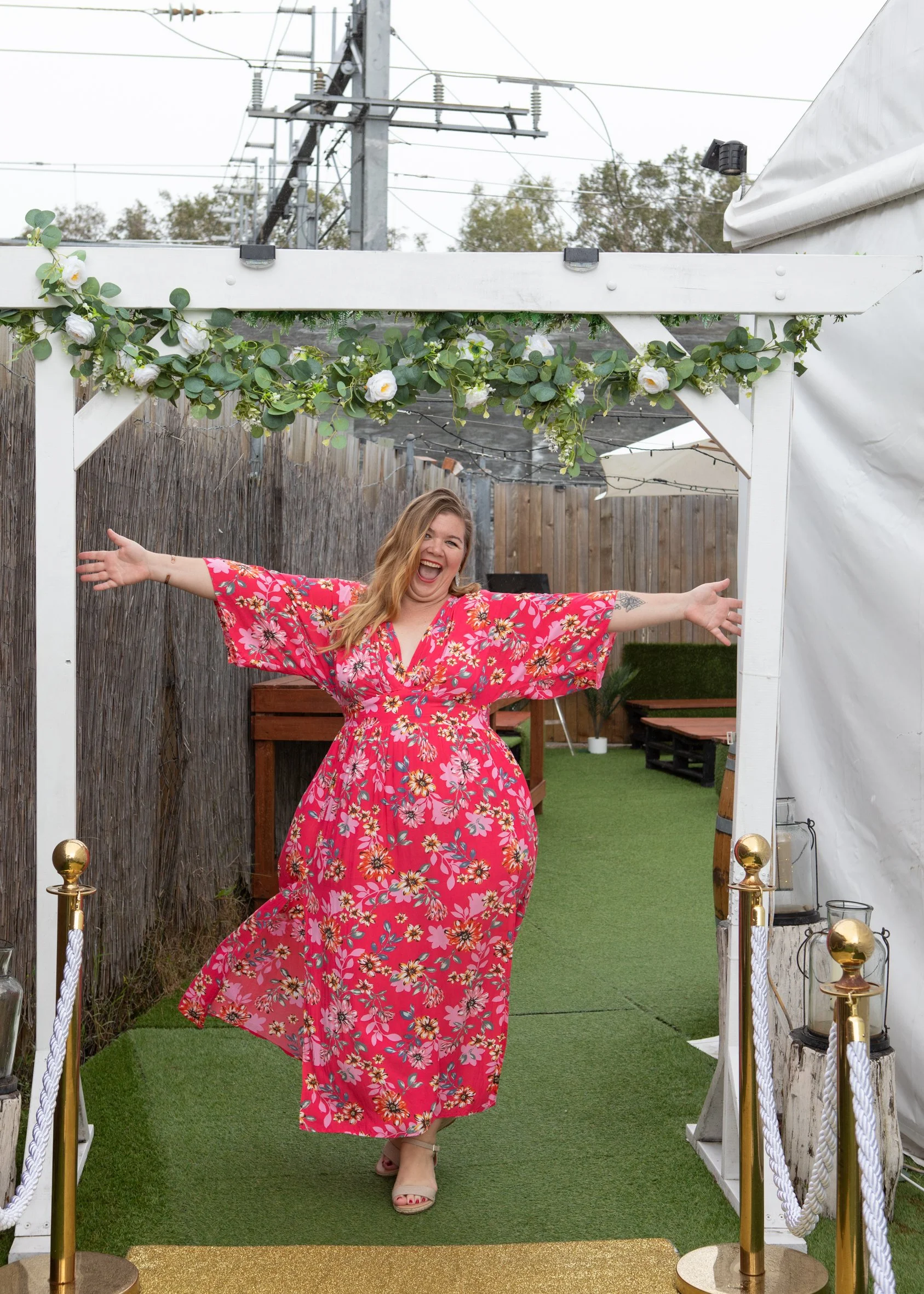 Jo Goddard founder of BraLess Brunches stands in a welcoming pose at the  braless brunch