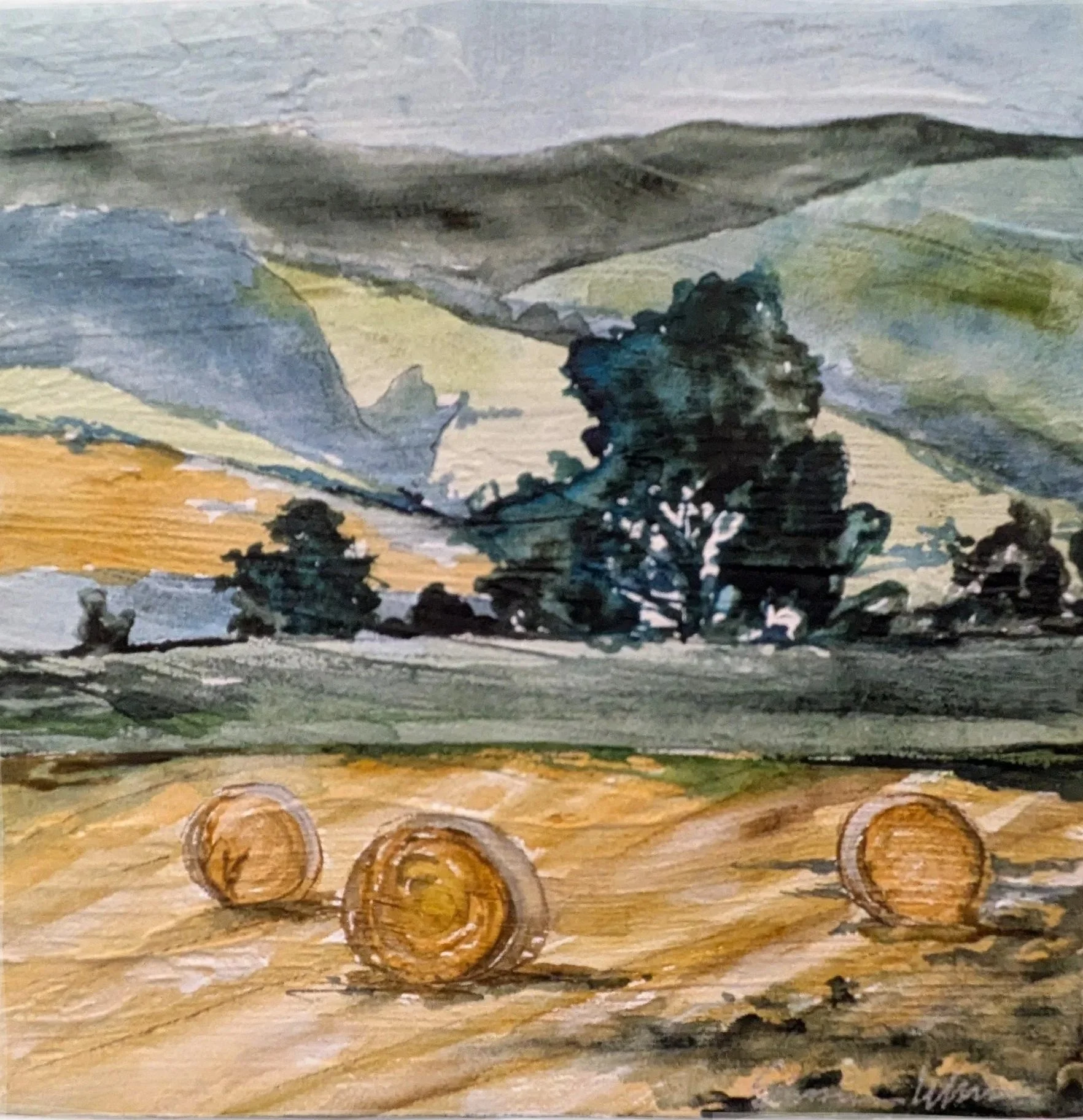 A watercolor landscape painting depicting a rural scene with three hay bales on a field in the foreground, several trees in the middle ground, and rolling hills under a cloudy sky in the background.