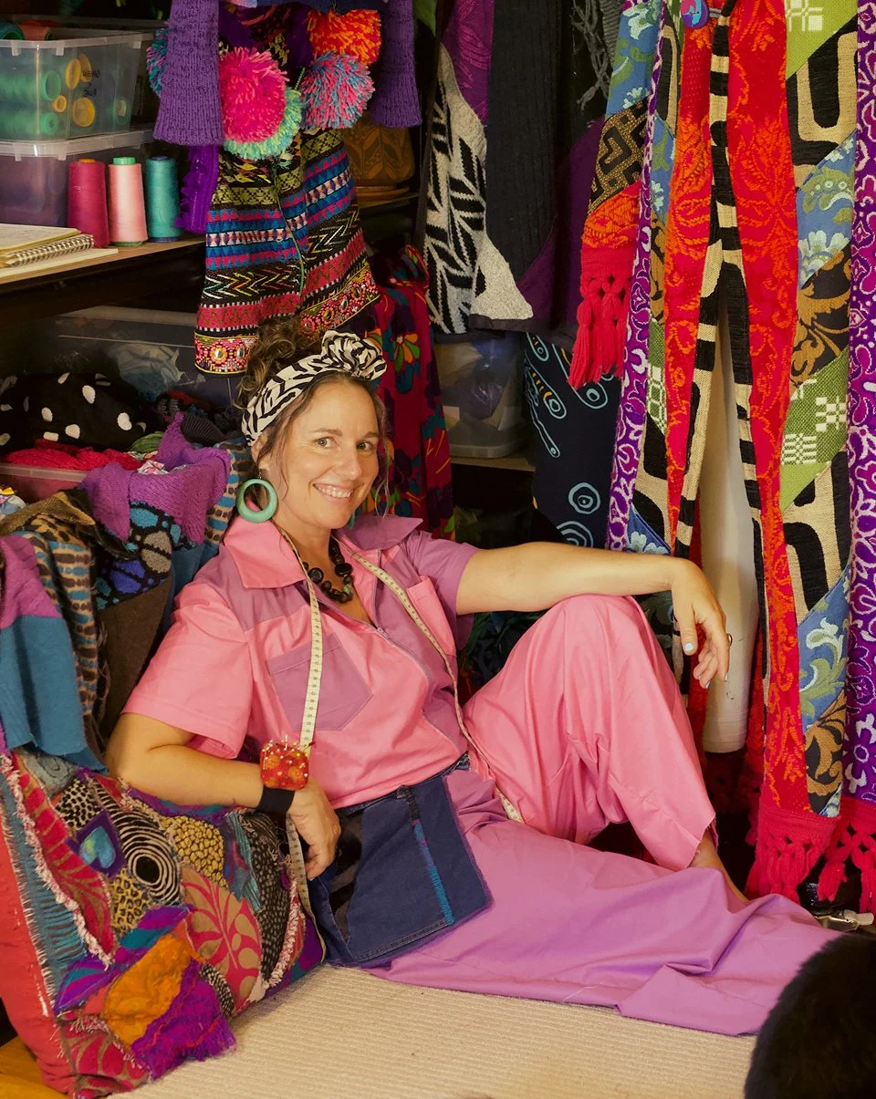 Corinne Wilson of Ragmaiden Repairs surrounded by garments in her Northern Rivers clothing repair studio