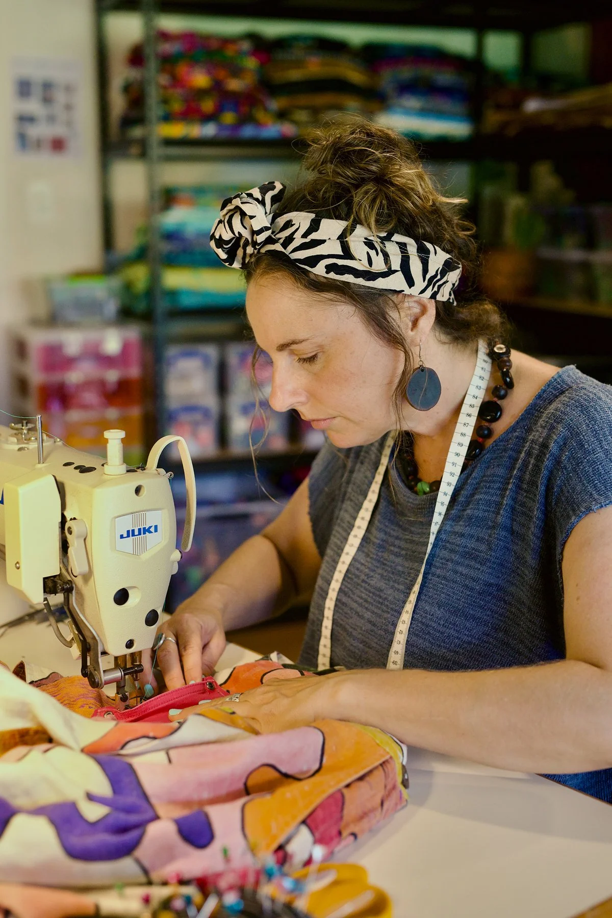 Corinne Wilson using a sewing machine for clothing alterations and garment repair projects.