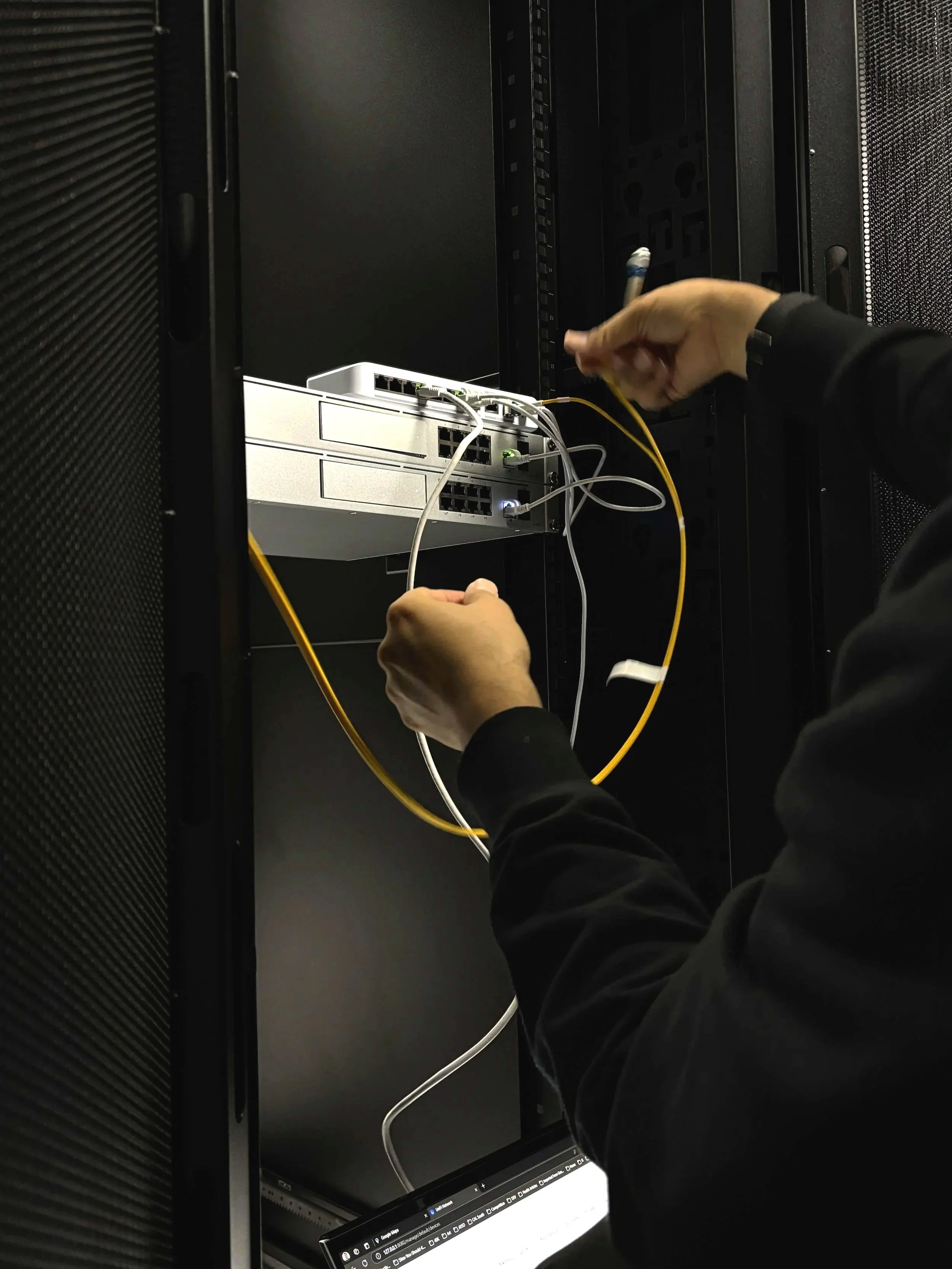Technician connecting cables in a data center server rack.