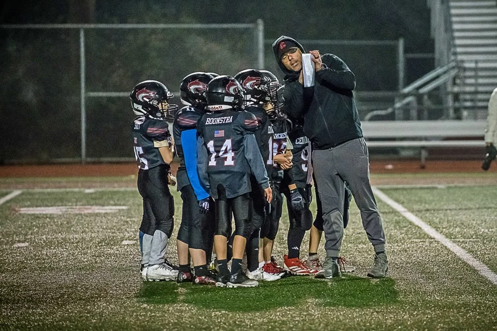 Coach gives the play to his team in the huddle