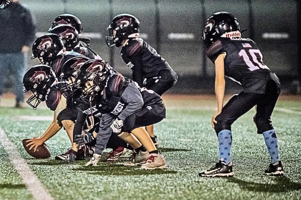 Jr. Red Wolves Rookies football players lined up for a play on the field.