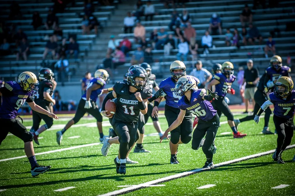 Youth football game with kids running on a field.