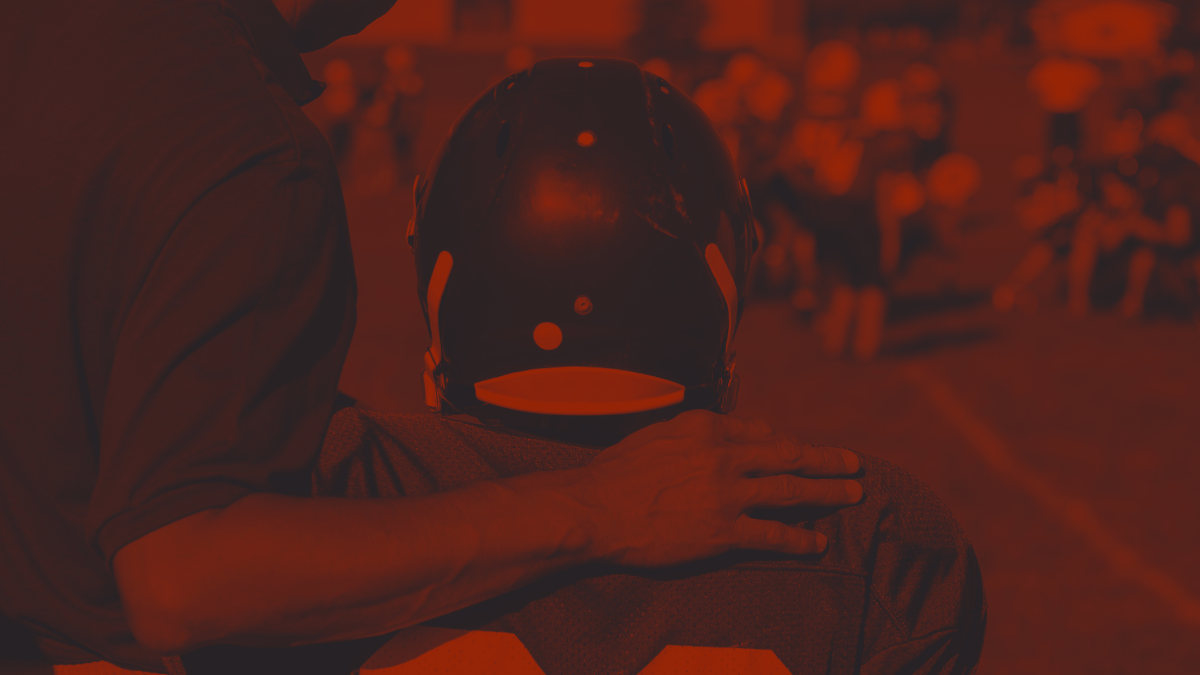 Football Coach with arm around young player shoulder