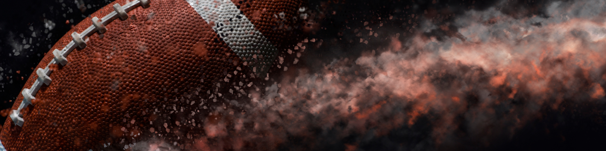 Close-up of an American football with motion blur and dust particles in the background.