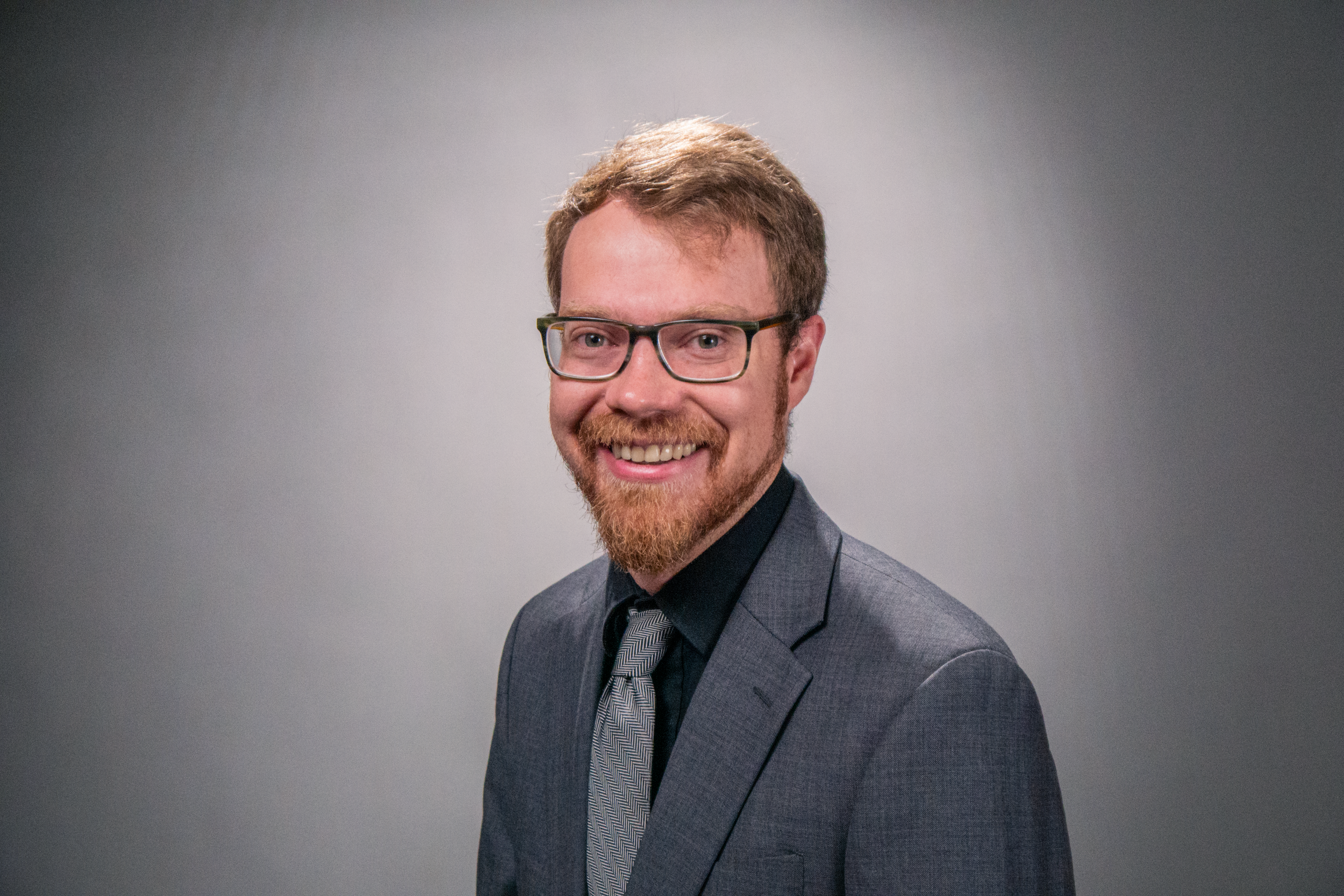 Blaise Jorgensen, candidate for Washoe County Public Administrator, standing against a gray background.