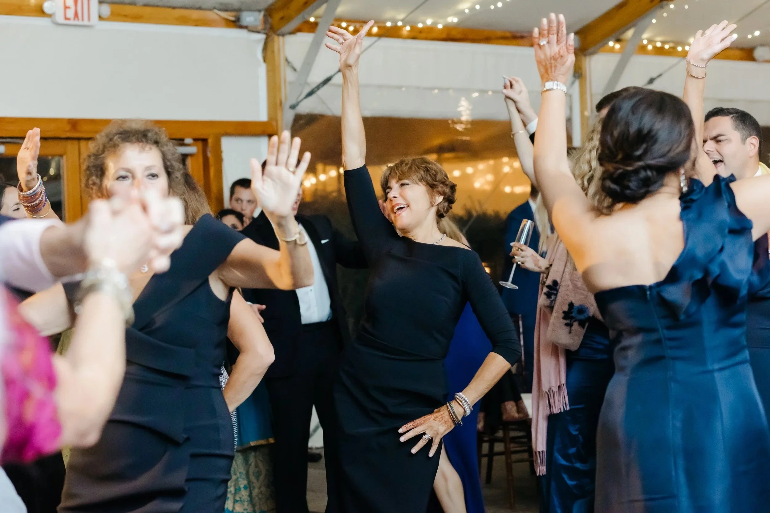 People dancing and having fun at a party or celebration in a decorated indoor venue.