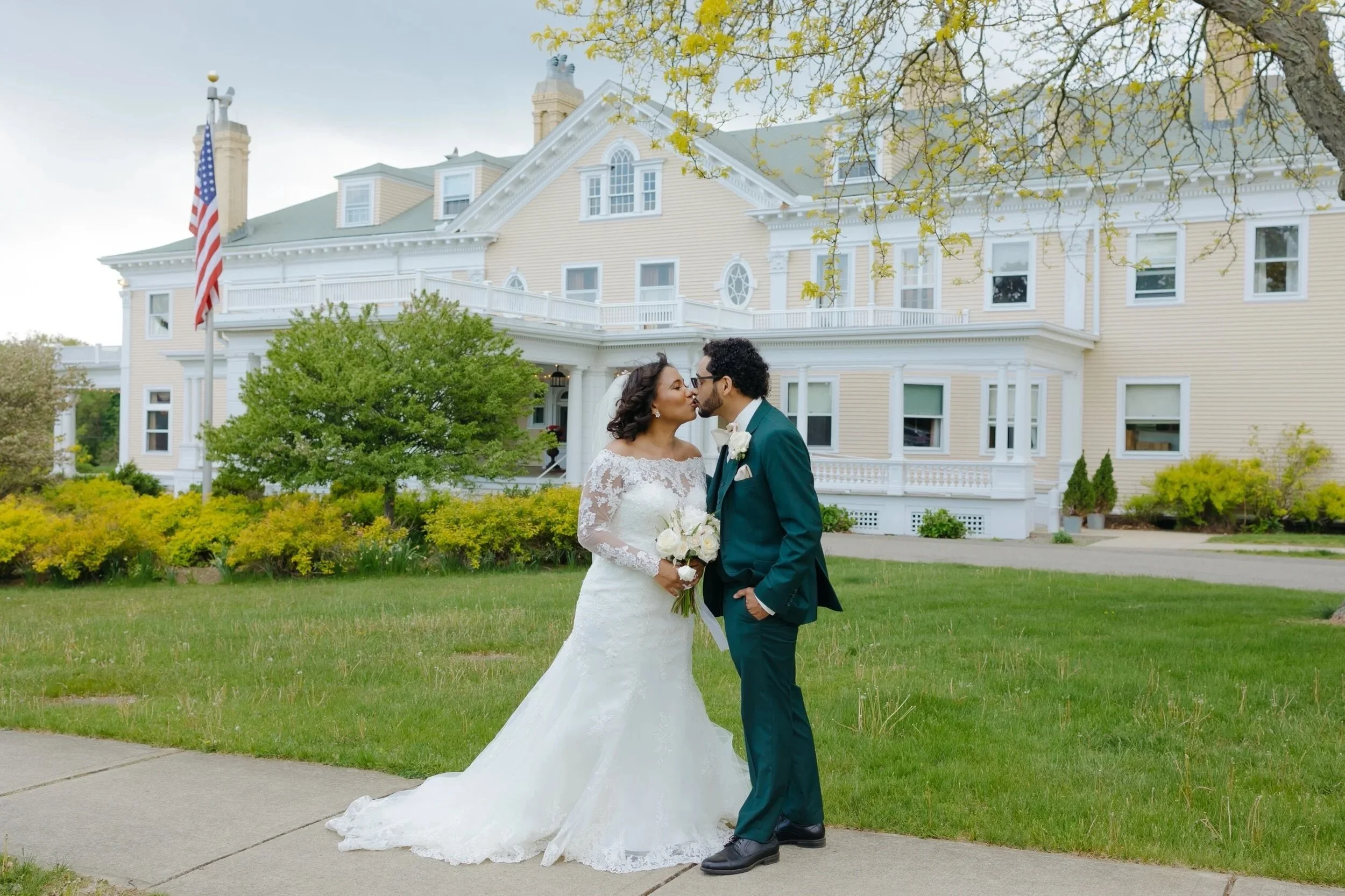 A newlywed couple sharing a kiss outside the Endicott Estate