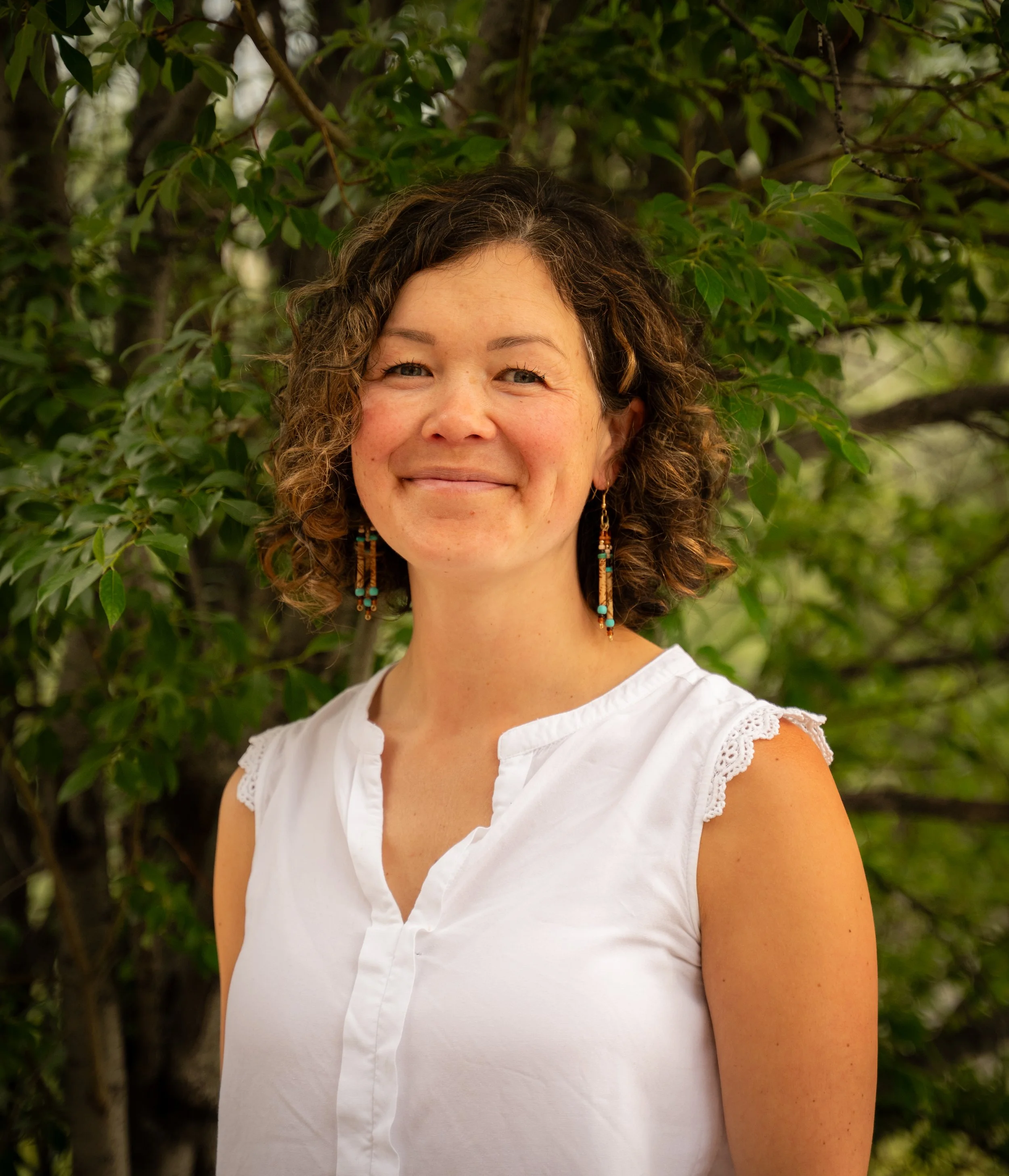 Headshot of Jasmine Verrall with forested background.