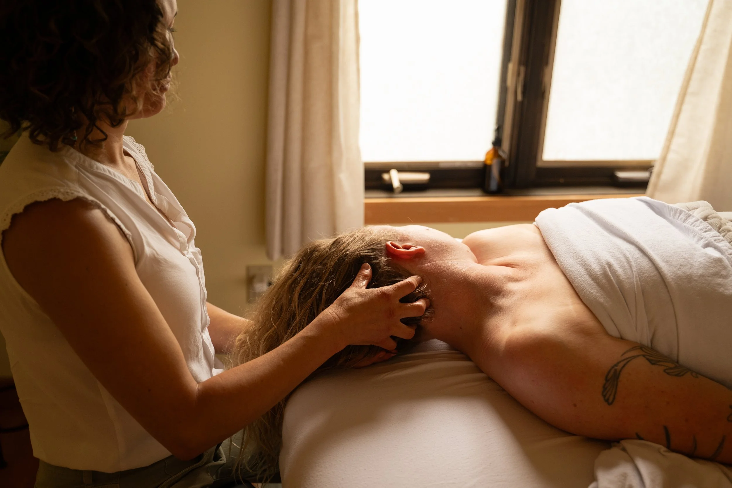 Client receiving craniosacral work on neck and head.