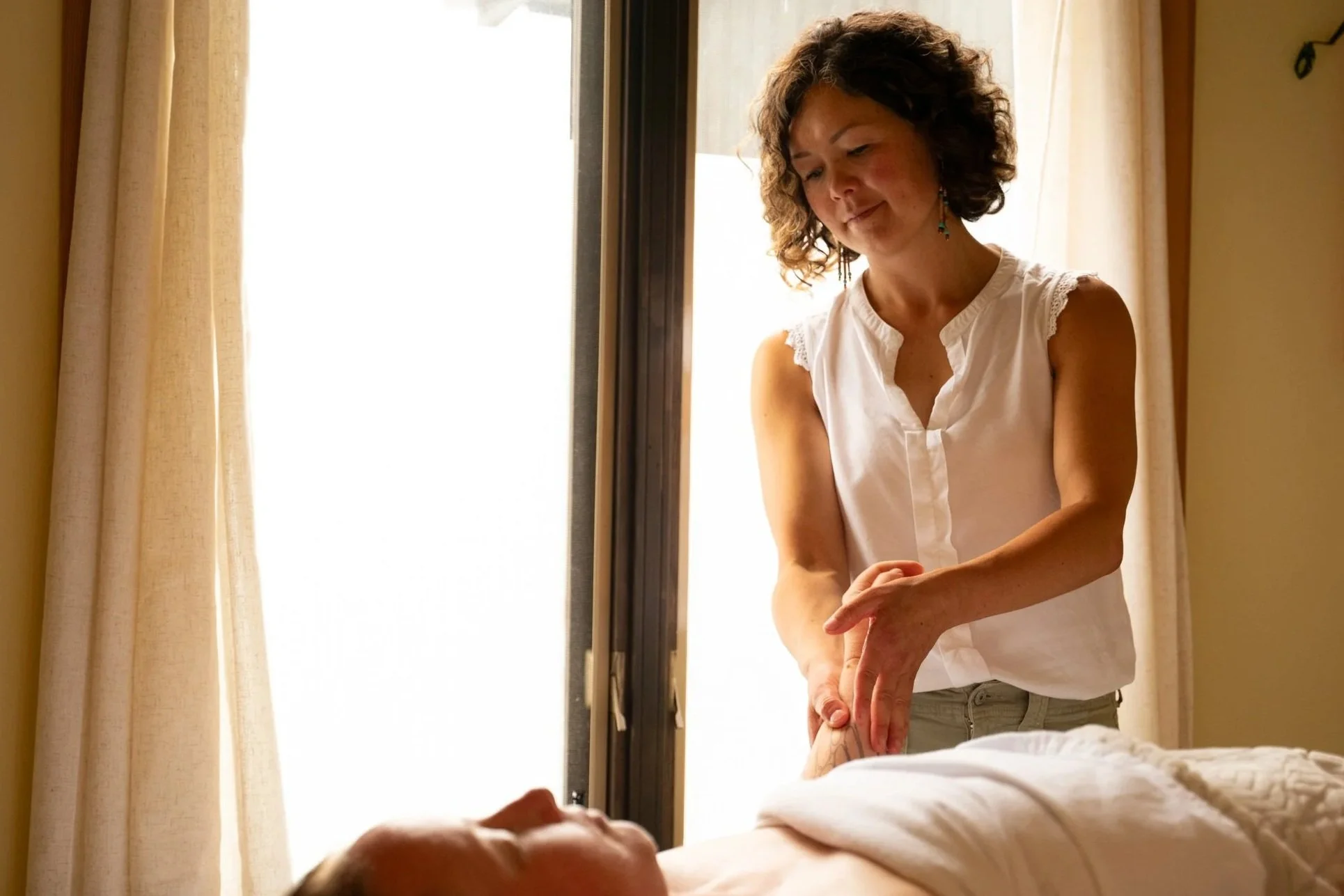 Client's left hand being massaged by therapist in a caring and nurturing way