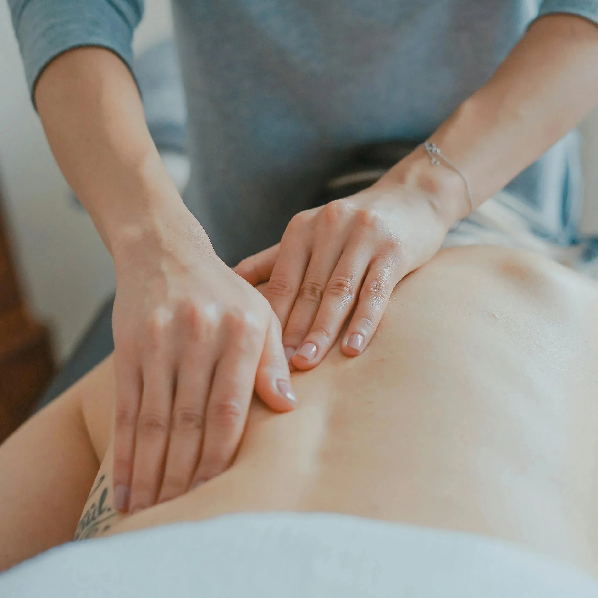 Person receiving a back massage in a spa or massage therapy setting.