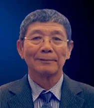 A portrait of an older man with glasses, short black hair, wearing a suit and tie, against a blue background.