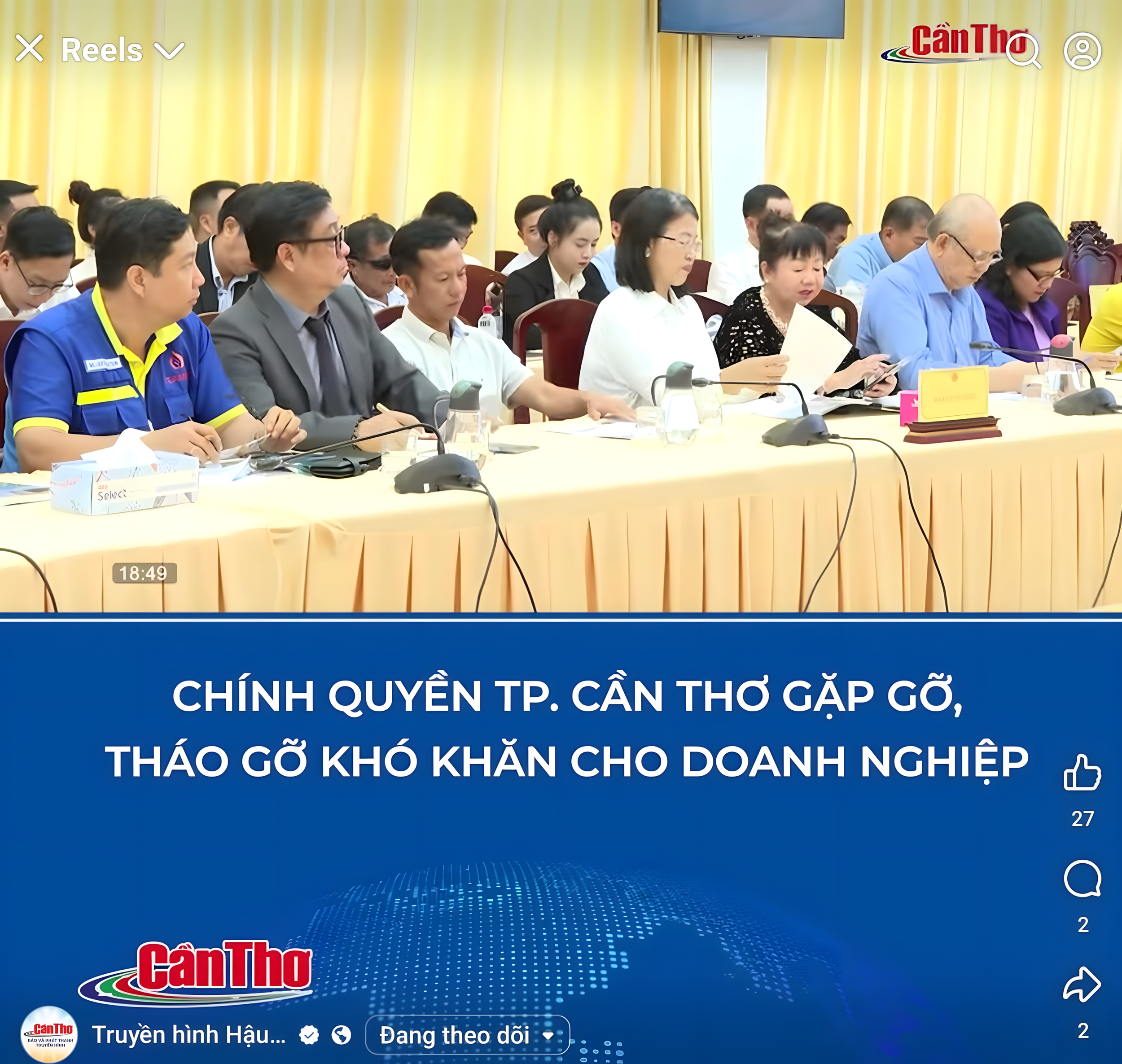 A group of people attending a conference or meeting, sitting at long tables with microphones and documents. A blue banner with Vietnamese text is visible at the bottom.