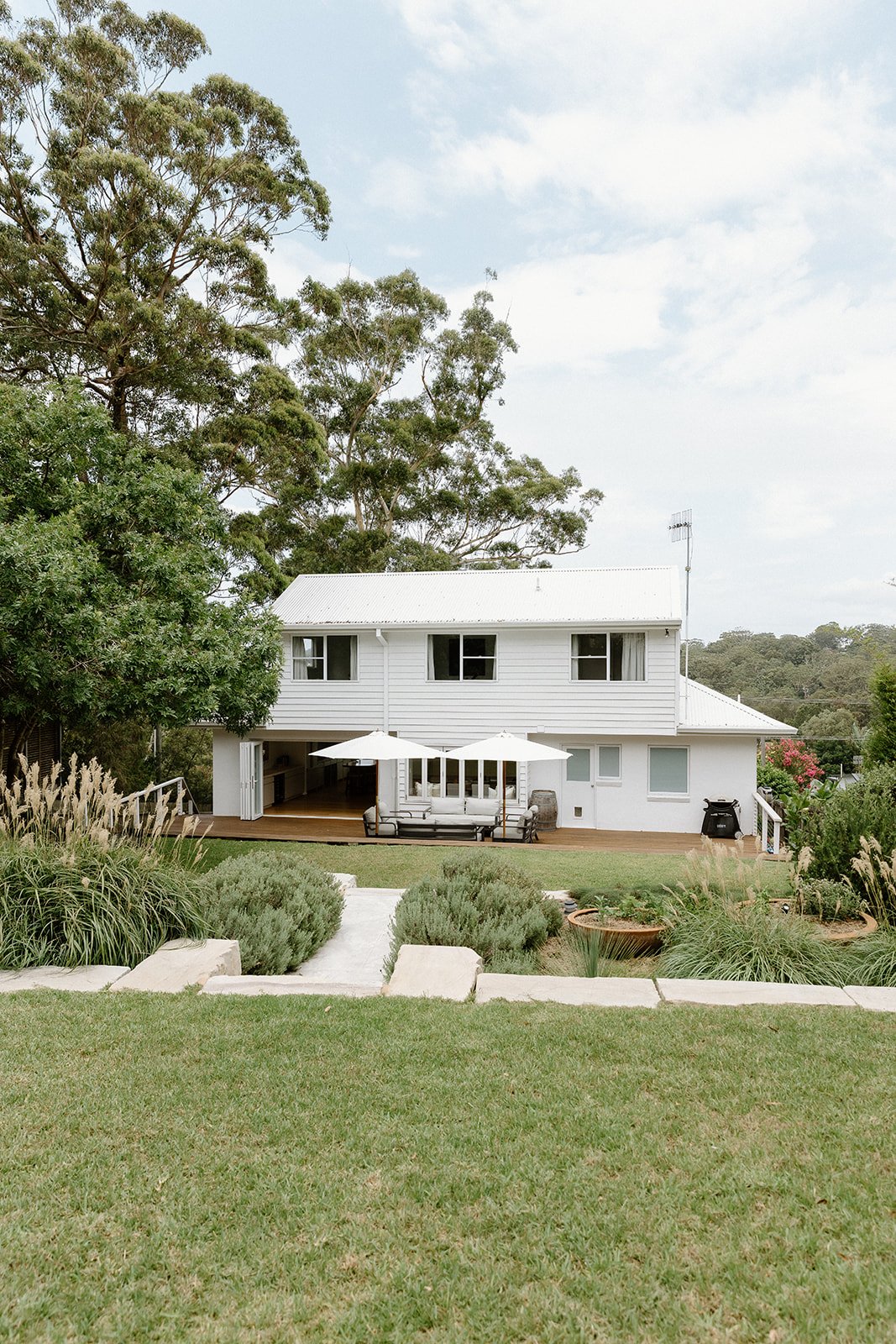 Outdoor entertaining area Wamberal with natural landscaping and stone elements by Everyday Designs. 